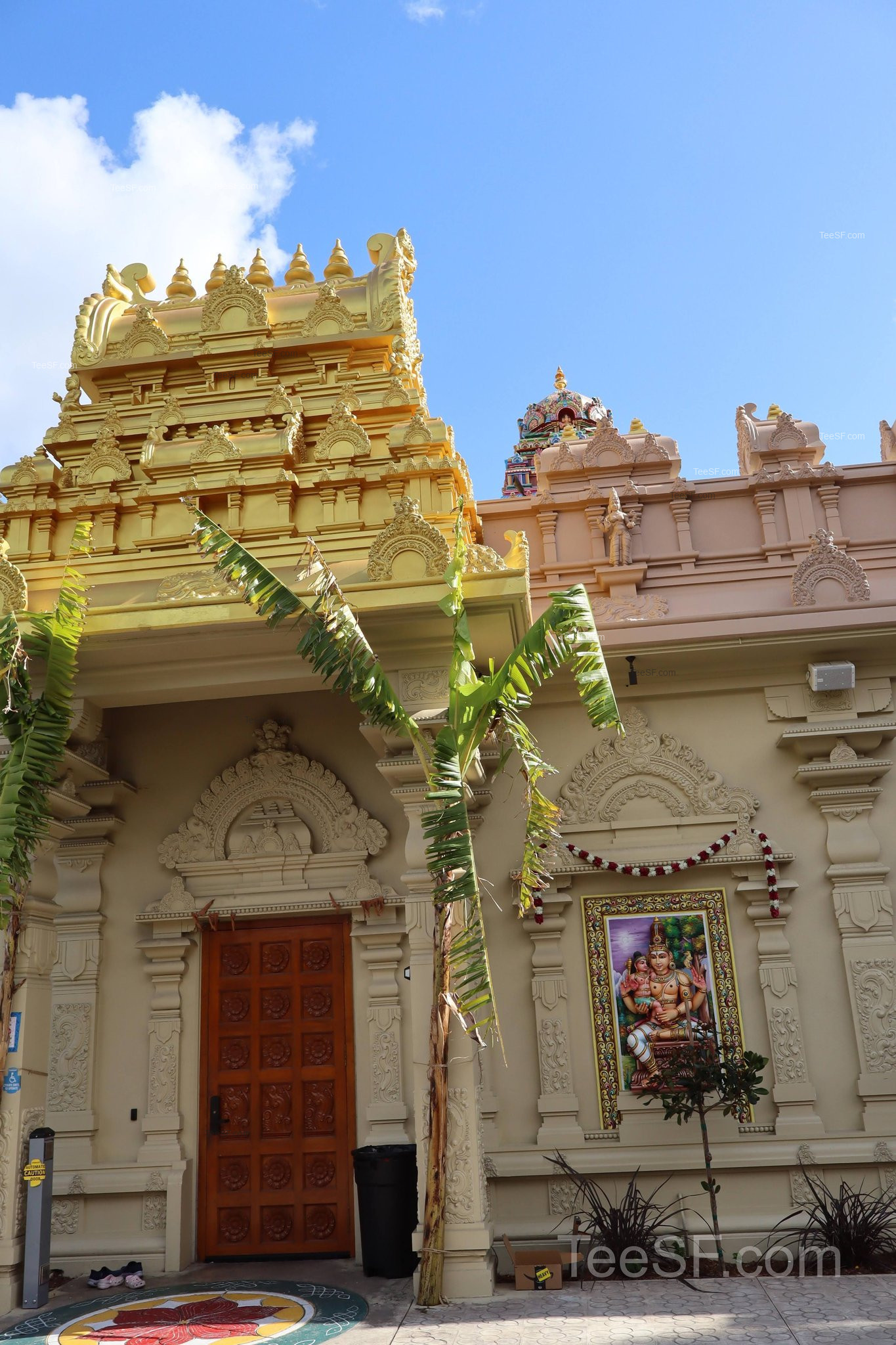 An exterior temple doorway with carved stone and gold architectural detail.